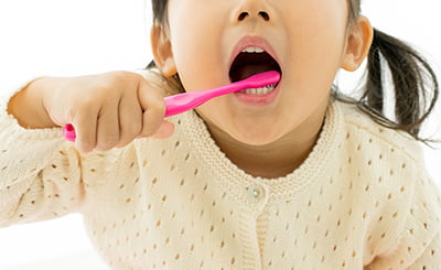 歯磨きをする女の子の写真